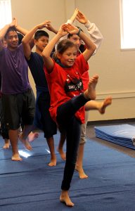 students in PE doing a gymnastics stretch